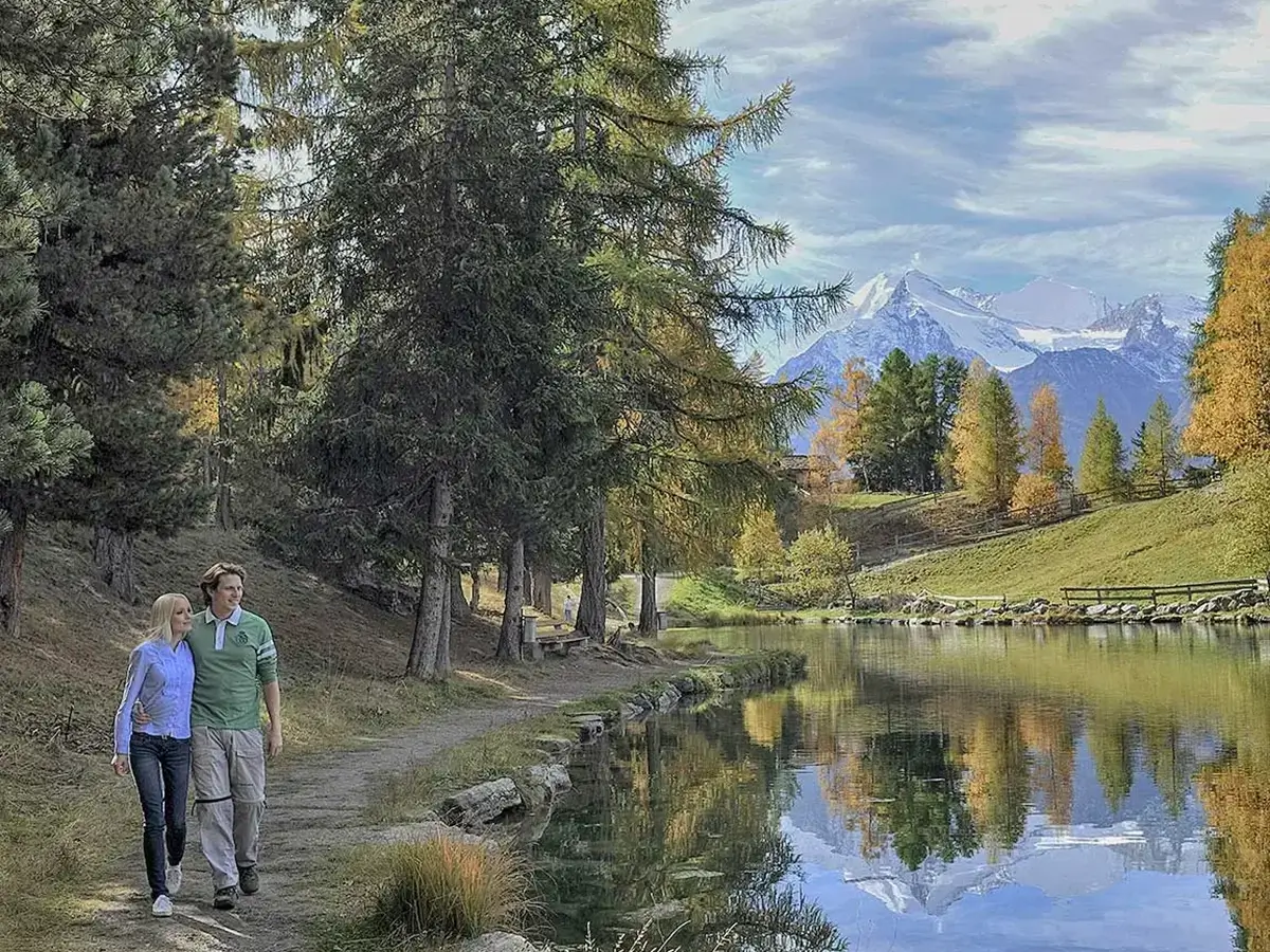 Paar am Wandern beim Bergsee in Grächen